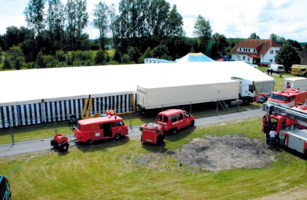 Festplatz beim Feuerwehrfest mit ausgestellten Fahrzeugen und Besuchern